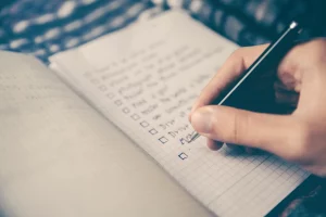 adult hand writing to do list with pen